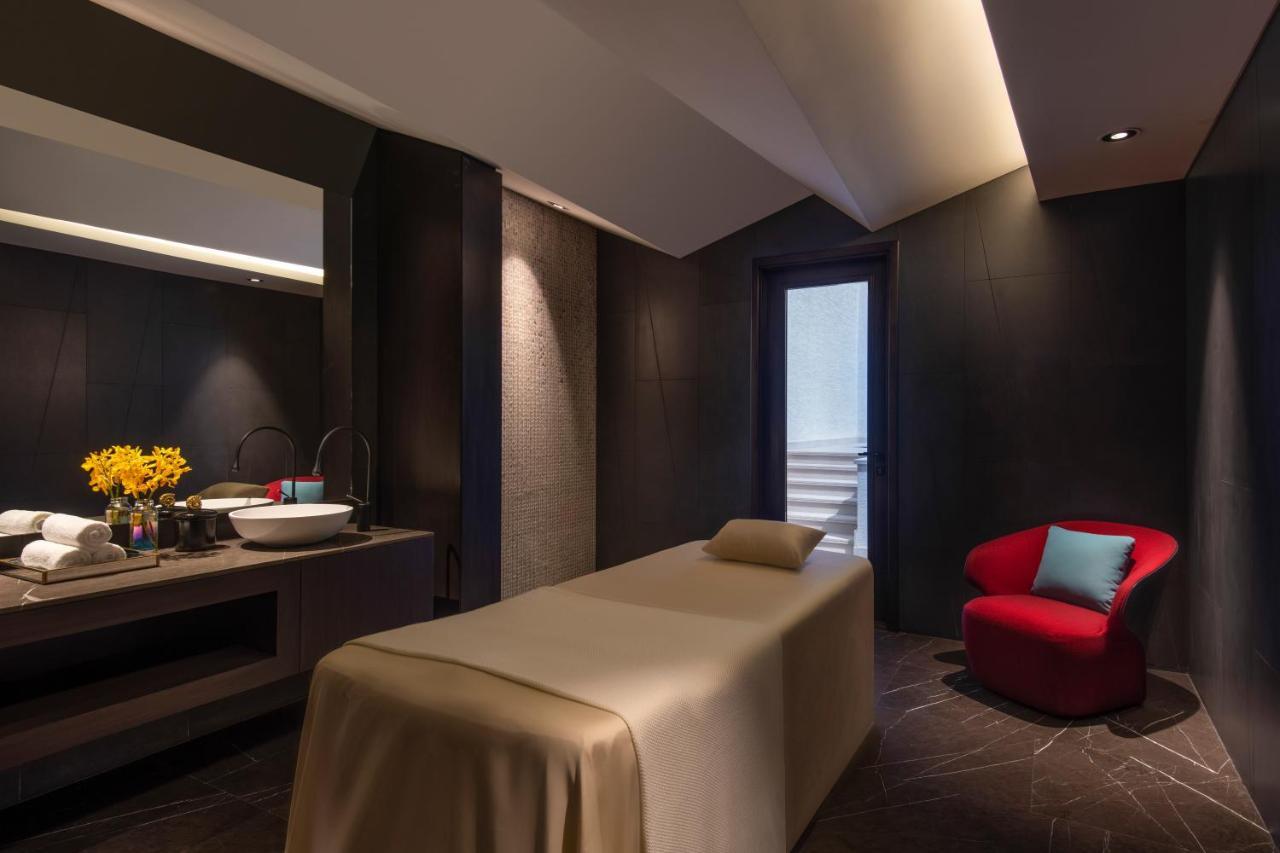Steigenberger Hotel Doha Exterior photo The photo shows a serene spa room designed for relaxation and treatments. It features a massage table covered in a neutral-colored fabric, positioned centrally in the room. On one side, there is a sleek vanity area with a sink, where a small vase of 